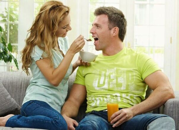 A woman feeds a man with products to increase potency